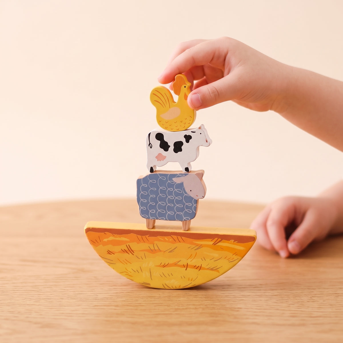 Farm animals balanced on the curved wooden hay piece