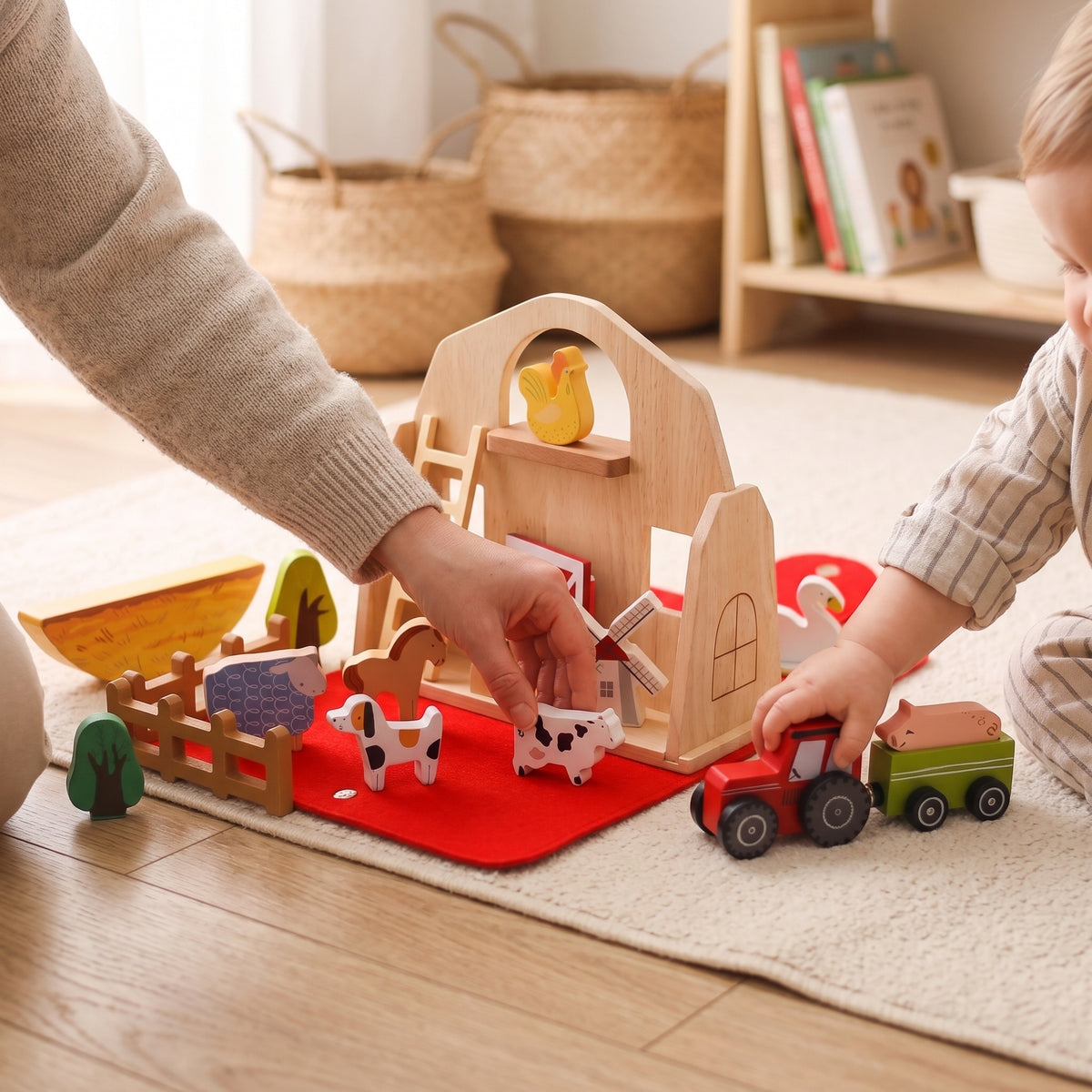 Parent and toddler playing with the wooden farm barn set
