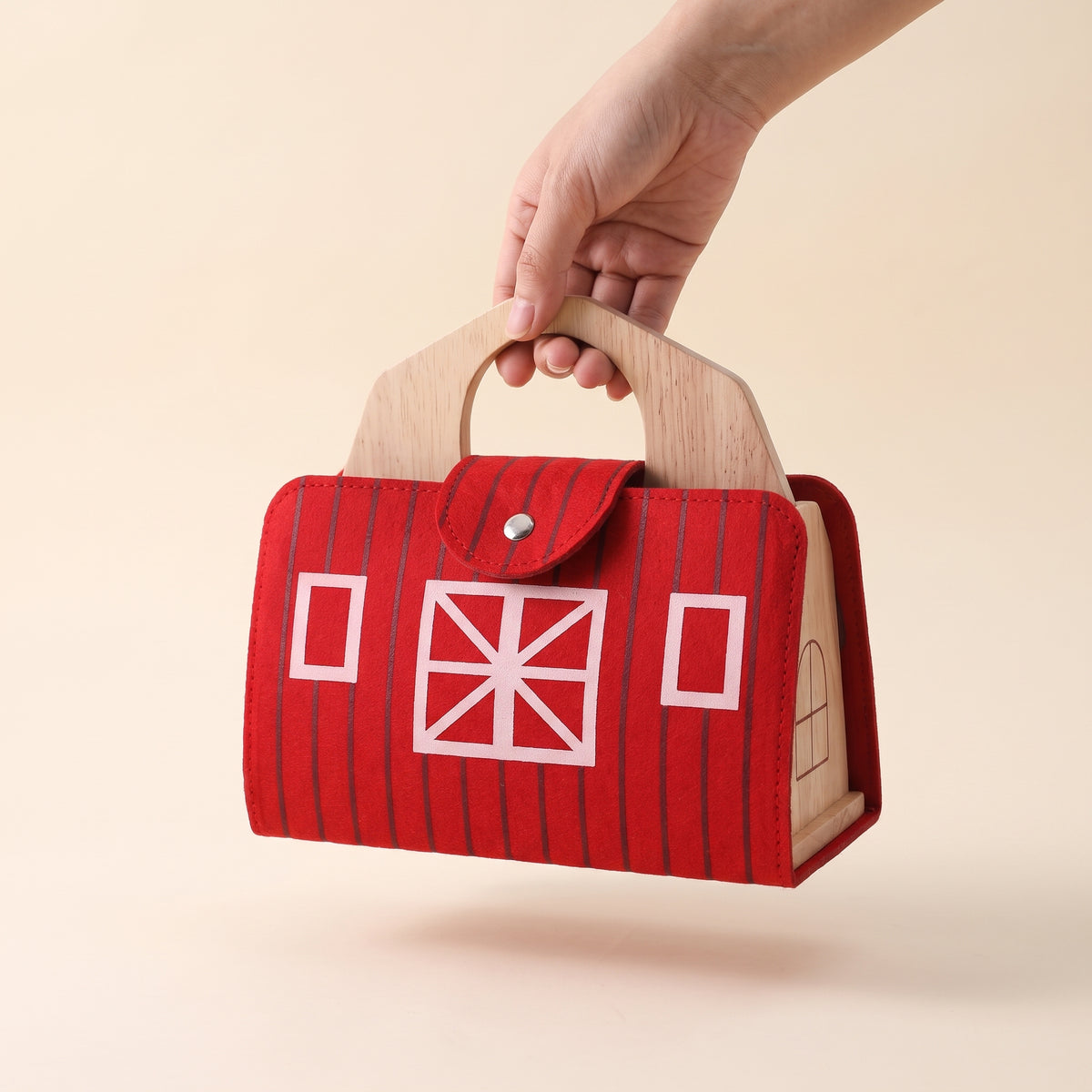 Wooden farm barn folded into its red felt carry case