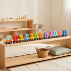 Wooden magnetic number train running along a low Montessori shelf