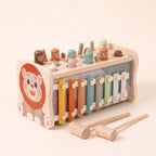 Wooden lion hammer bench with xylophone, hammers, mallets and fishing rod on a cream background