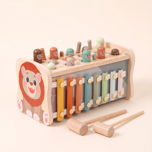 Wooden lion hammer bench with xylophone, hammers, mallets and fishing rod on a cream background