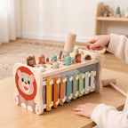 A child's hand tapping a wooden mole with the hammer