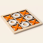 Wooden noughts and crosses board with orange crosses and white noughts