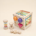 Wooden shape sorter cube with rainbow cords and three wooden baby rattles